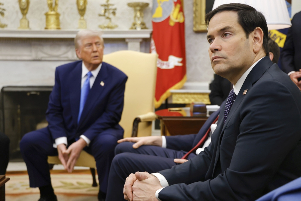 Secretary of State Marco Rubio, right, listens as President Trump, left, meets with France's President Emmanuel Macron in the White House on Feb. 24. (Pool via AP)