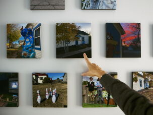Daryl McCool points to photographs displayed in her rebuilt home in Superior, Colorado. McCool lost the small, single-story historic miner's shack where she and her family had lived for 25 years when it was destroyed in the Marshall Fire on Dec. 30, 2021. The fire is part of the broader climate-related costs facing Colorado communities.