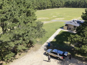 An Ocean County Sheriff's Office drone lifts off at the Ocean County Fairgrounds on Sept. 4 as Chief Warrant Officer Kevin Fennessy (left) and Officer Adam Wright (at right, with the controller) stand near a department SUV.<br>
