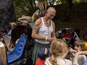 John Nurse speaks to children about his soapbox car and allows them to sit on the vehicle between races at the Portland Adult Soapbox Derby.