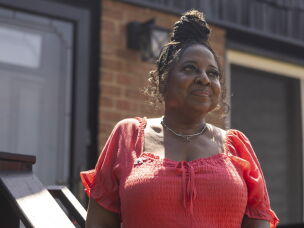 Kimberly Holmes-Ross stands outside the home her parents bought in the early 1960s, when their only option was in the city's Black neighborhood, the 5th Ward. She used some of the reparations money she received to add a porch where her mother often sat outside for fresh air during the COVID-19 pandemic.