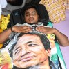 A reclining protestor covers himself with a banner printed with a portrait of Sonam Wangchuk, a prominent activist who was forcefully transferred to a hospital by the police as he staged a hunger strike in support of a movement led by Cockroach Janta Party, at a protest in New Delhi, India, Wednesday, July 22, 2026.