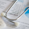 A stethoscope and calculator sit on top of a medical treatment expense bill. Indiana is the latest state to experiment with limiting what hospitals can charge, to try to get a handle on high health costs.