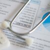 A stethoscope and calculator sit on top of a medical treatment expense bill. Indiana is the latest state to experiment with limiting what hospitals can charge, to try to get a handle on high health costs.