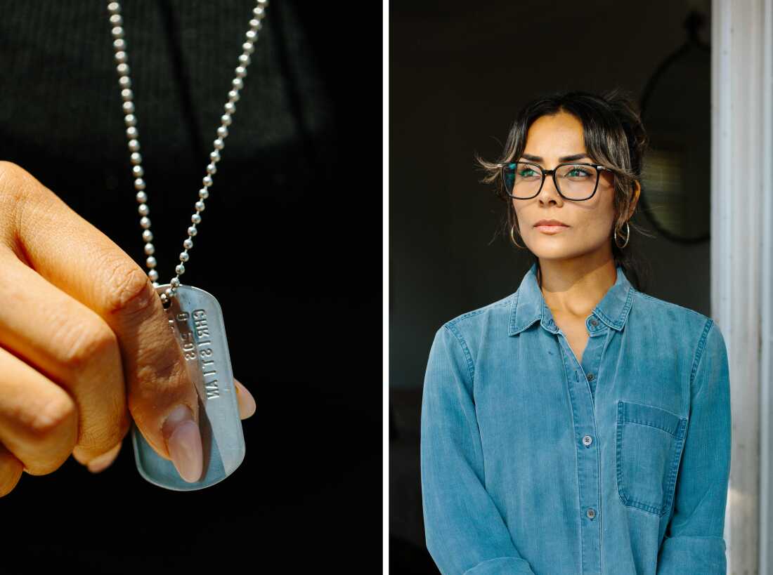  A portrait of Serrato in a doorway. She is wearing an oversized denim shirt with dark pants, she has glasses and her hair is in a ponytail.