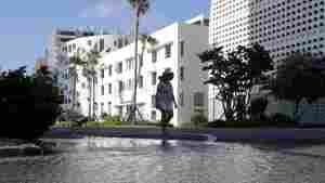 A woman in Miami Beach, Fla. walks past street flooding from a high tide.