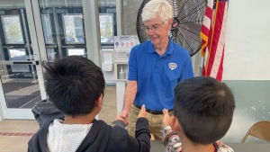 Fourth-graders line up to shake hands with Dennis Cuddy, one of the volunteers with Grandpas United in White Plains, New York.