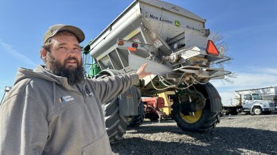 Matt Ubel, standing on his farm near Wheaton, Kansas, motions to the fertilizer spreader he’ll use to spread urea fertilizer this spring.