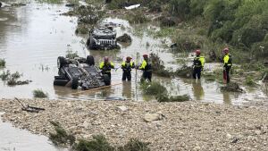 Authorities respond after vehicles were swept away by floodwaters in San Antonio on Thursday.