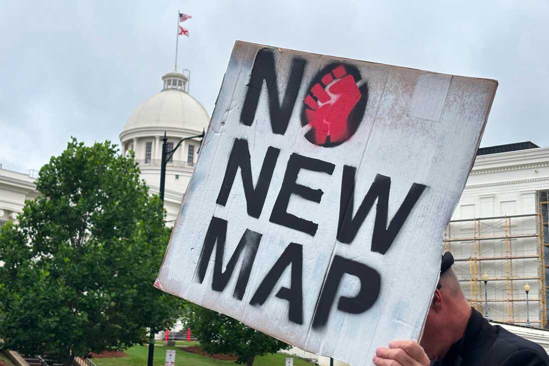 A demonstrator holds up a sign outside the Alabama Statehouse in Montgomery on Thursday.
