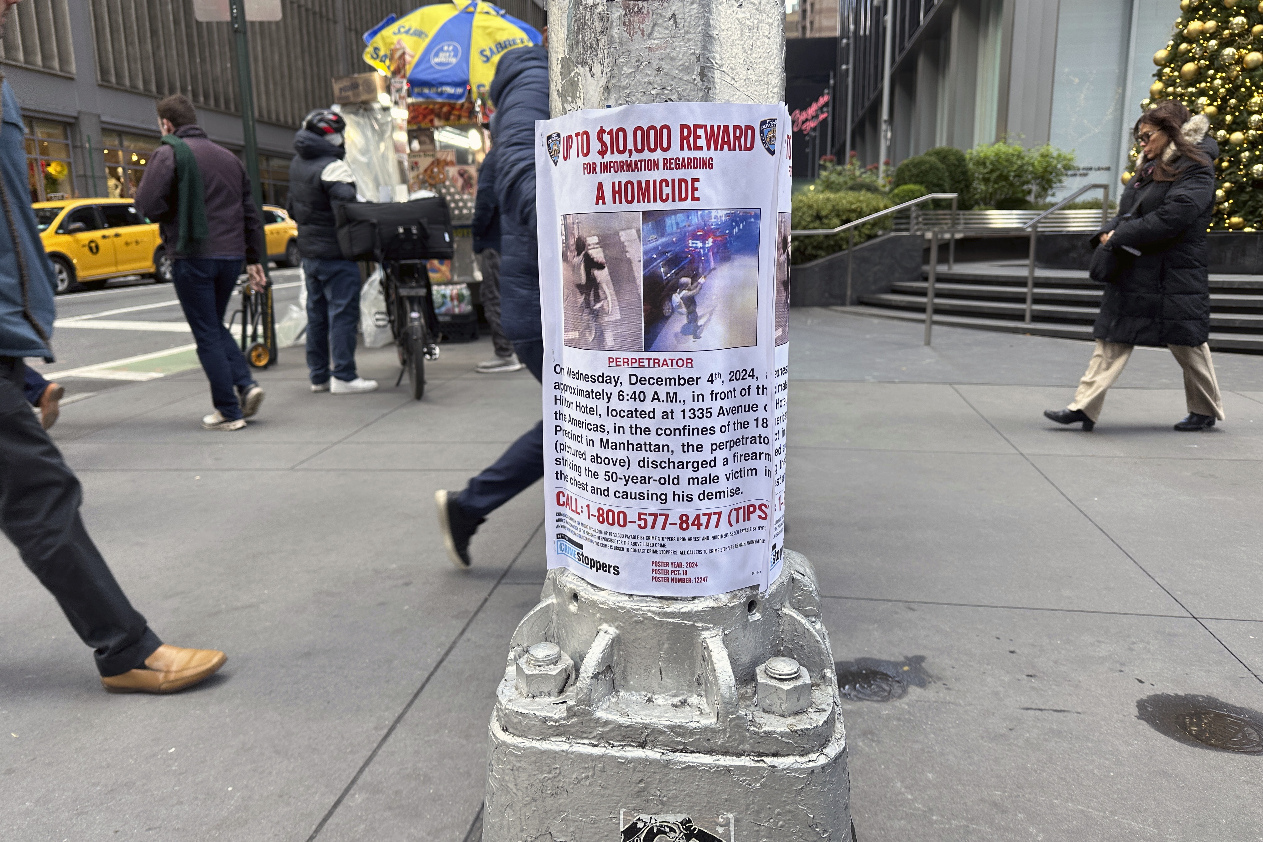 A reward poster hangs on a light pole outside the New York Hilton Midtown Hotel in New York last week. The NYPD offered up to $10,000 for tips leading to the shooting suspect's arrest, while the FBI offered up to $50,000. (AP)