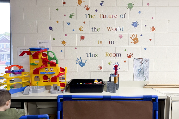 An inspirational message spelled out in colorful stencil letters decorates the wall of a classroom. It says: The Future of the World is in This Room.