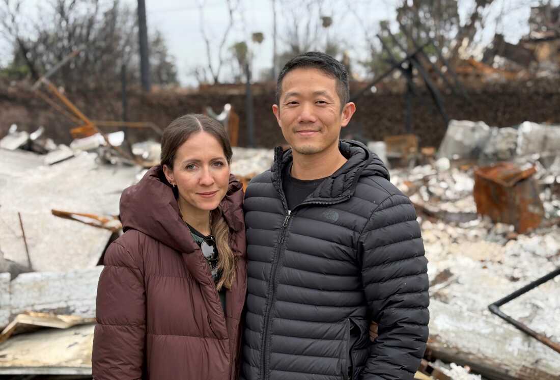 Patrick and Ruth Fong stand in front of their burned-down home.
