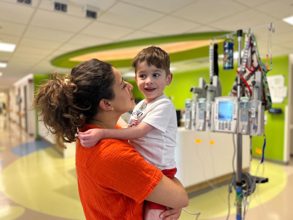 Caleb Strickland, 4, has an artificial heart pump keeping him alive while he waits for a transplant. Nora Strickland, his mom, says she feels far away from the Trump administration's disputes with universities.