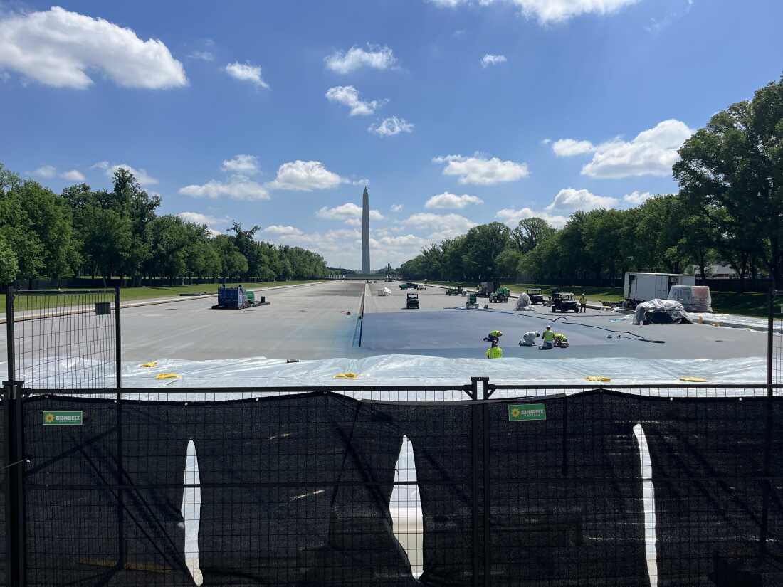 Workers paint a corner of the reflecting pool blue on Monday morning.
