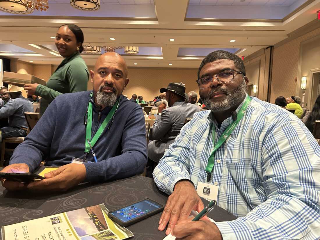 Finis Stribling III (left) and John Green II (right) take a break during the National Black Growers Council conference in New Orleans on Dec. 10, 2025. Both Stribling and Green were plagued by bad weather at the start of this year's growing season, and both said tariffs have only made things harder.