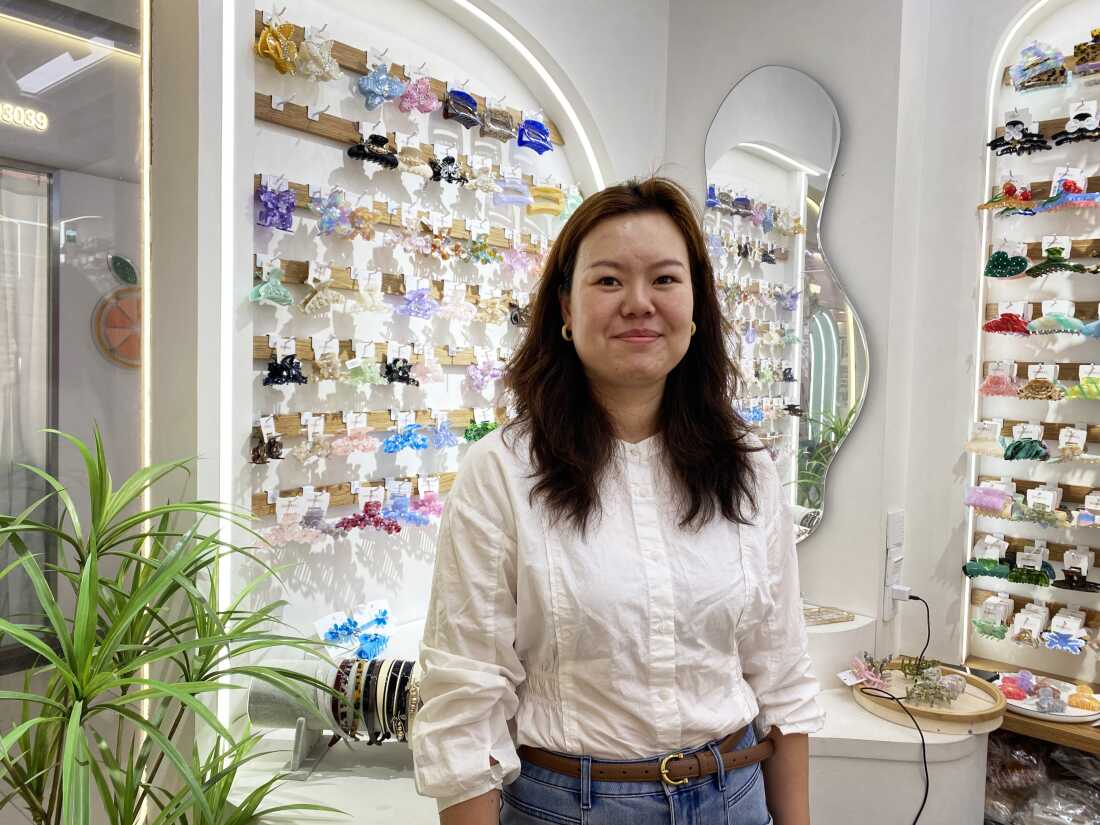 Nicole Zhang sells hair accessories at her storefront in the market.