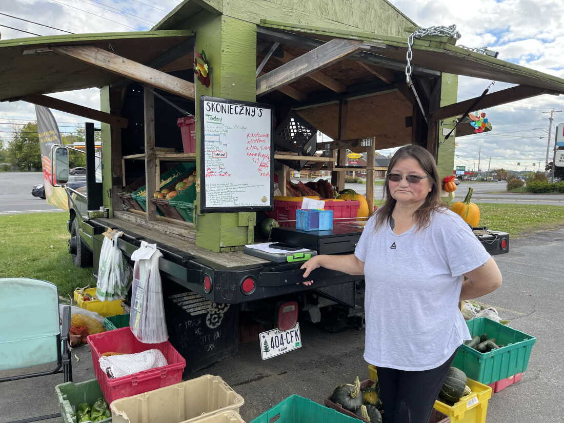 Sabrina Haney, 54, stands next to Skonieczny’s vegetable cart in Caribou, Maine.