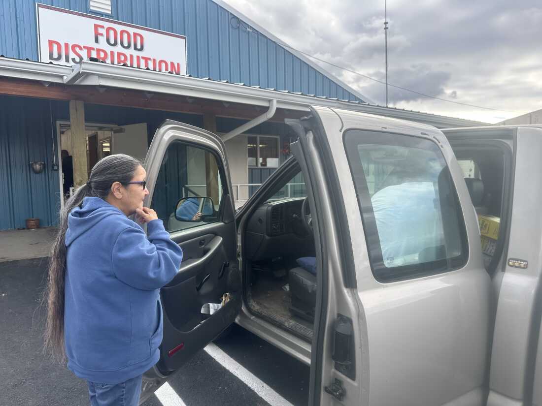 Mary Lefty watches warehouse workers load groceries onto her truck in St. Ignatius, Montana.