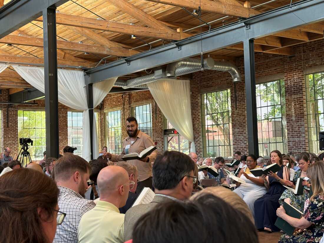 José Camacho-Cerna of Valdosta, Georgia leads the song he composed for the new edition of The Sacred Harp, "Lowndes," in the center of the hollow square.