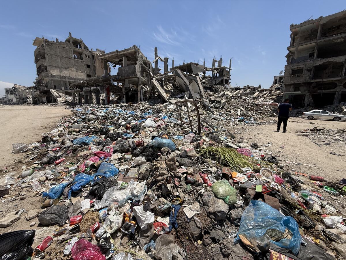 Piles of uncollected garbage and debris line a deserted street in al-Shuja'iyya, a neighborhood, lacking basic services and aid due to israel restrictions as expanding the orange zone.