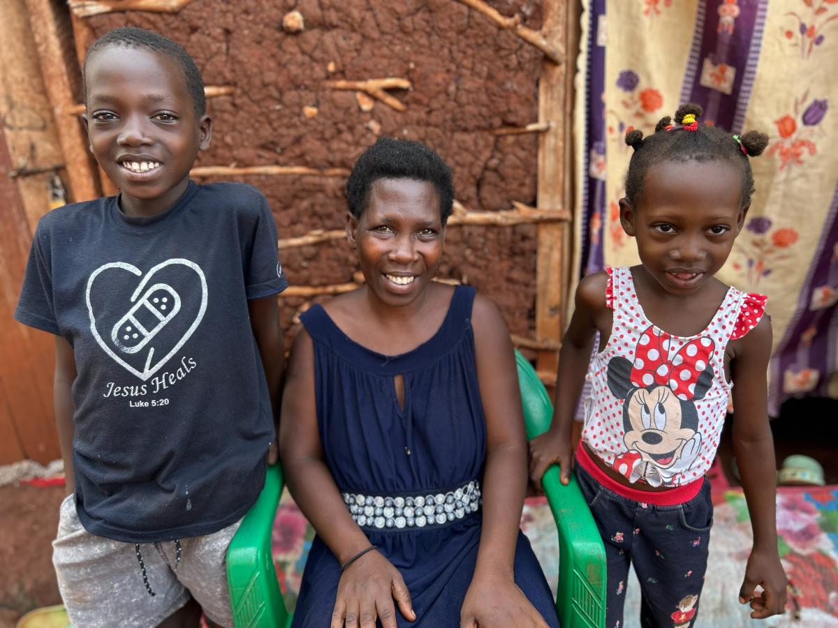 Deborah Nanyonga, who's battling cervical cancer, with her children Prosper (left) and Jovia outside their home near Uganda's Jinja-Tororo highway. She receives support from the Rays of Hope hospice — including food for her family.