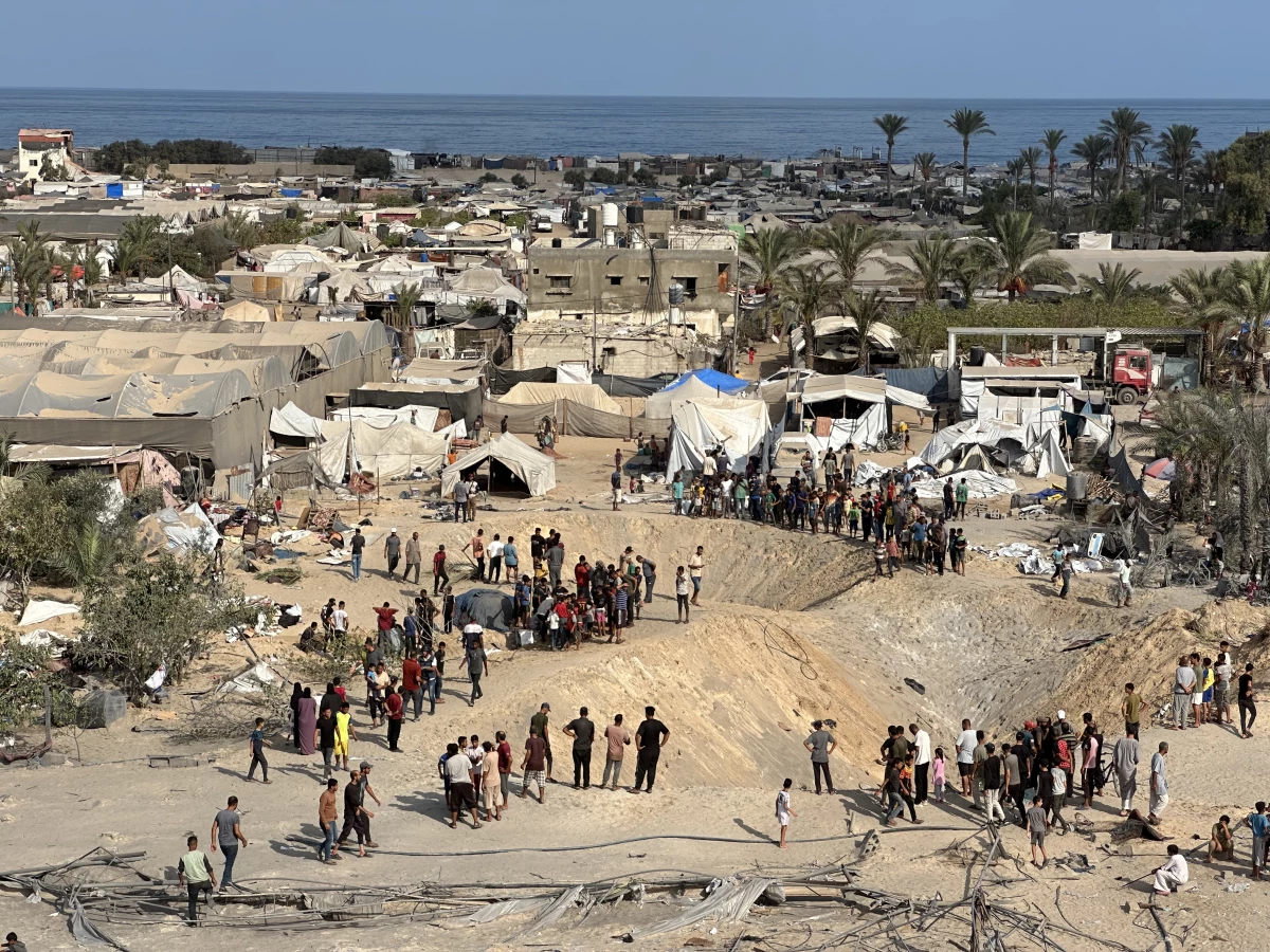 Dust and rubble cover tents and vehicles at the site of the attack.