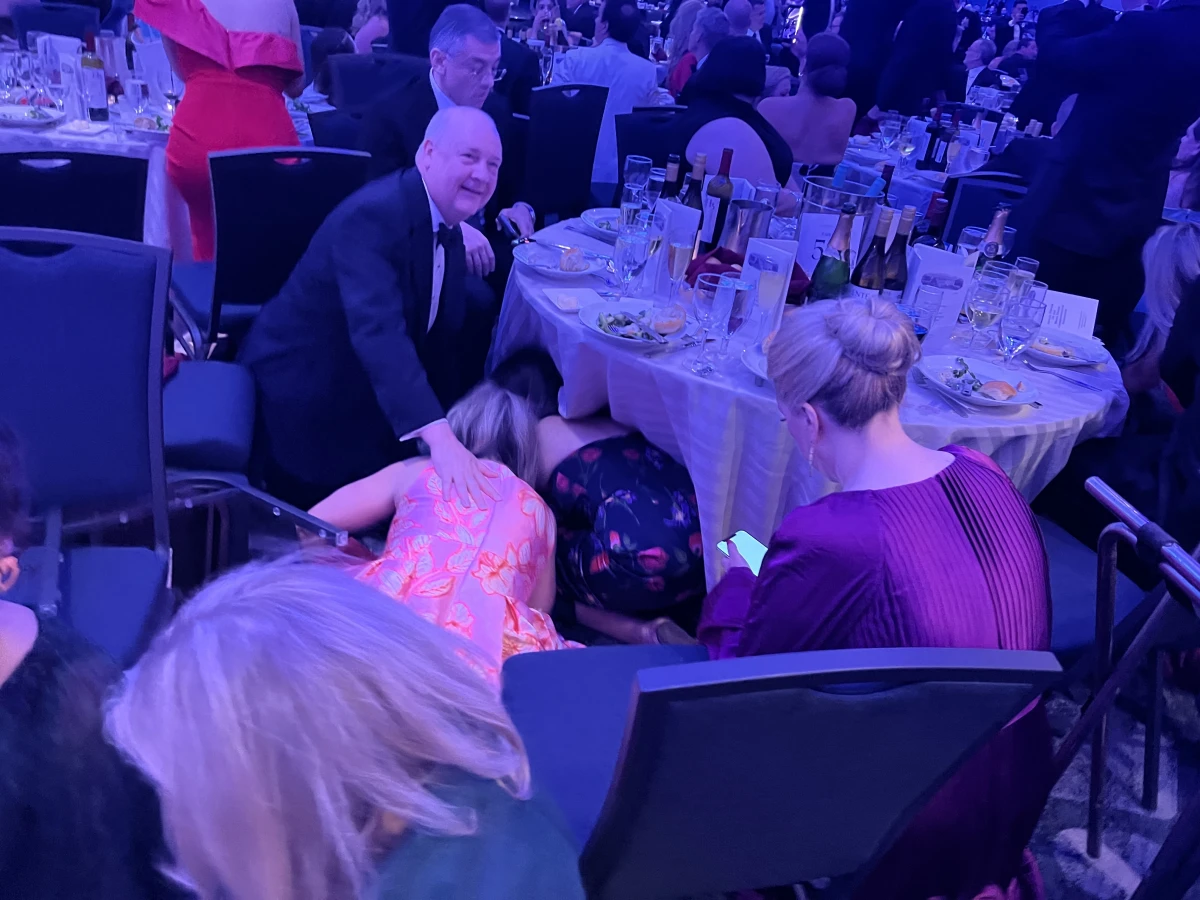 Attendees at the White House Correspondents' Dinner hide under tables after reports of gunshots at a security screening area at the Washington Hilton hotel on Saturday.