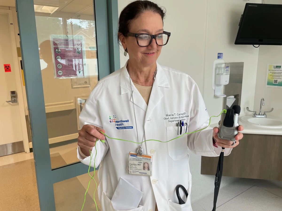Dr. Maria Carney holds an assisted hearing device that can be used to help older adults communicate in the ER. Patients often come to the emergency department without their hearing aids or glasses, compounding their confusion in a stressful place.