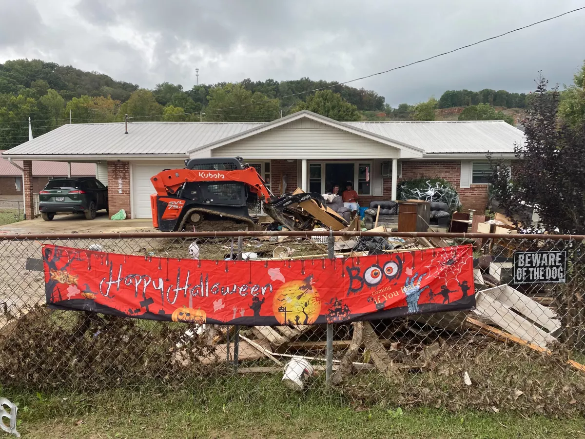 Trudy Hall’s house flooded after Hurricane Helene. She sits on the porch watching as all her belongings are loaded up by volunteers, to be taken to the dump.