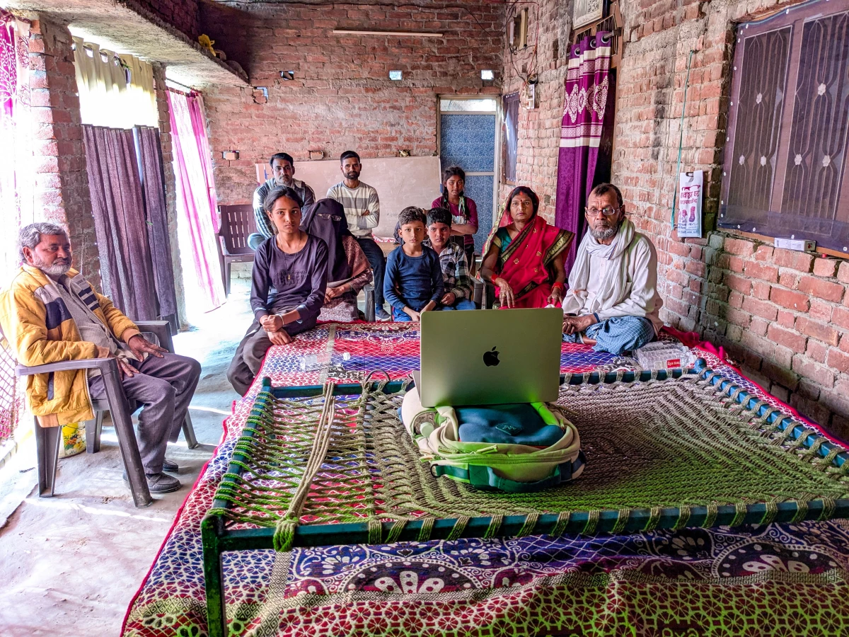 The families of two young men whose friendship inspired the movie Homebound gather for a makeshift screening on the balcony of the home of Mohammad Saiyub.