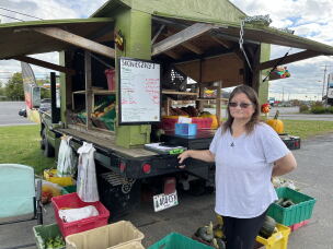 Sabrina Haney, 54, stands next to Skonieczny's vegetable cart in Caribou, Maine.