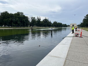 Workers battle the fast-growing common algae in the Lincoln Memorial Reflecting Pool on Thursday.