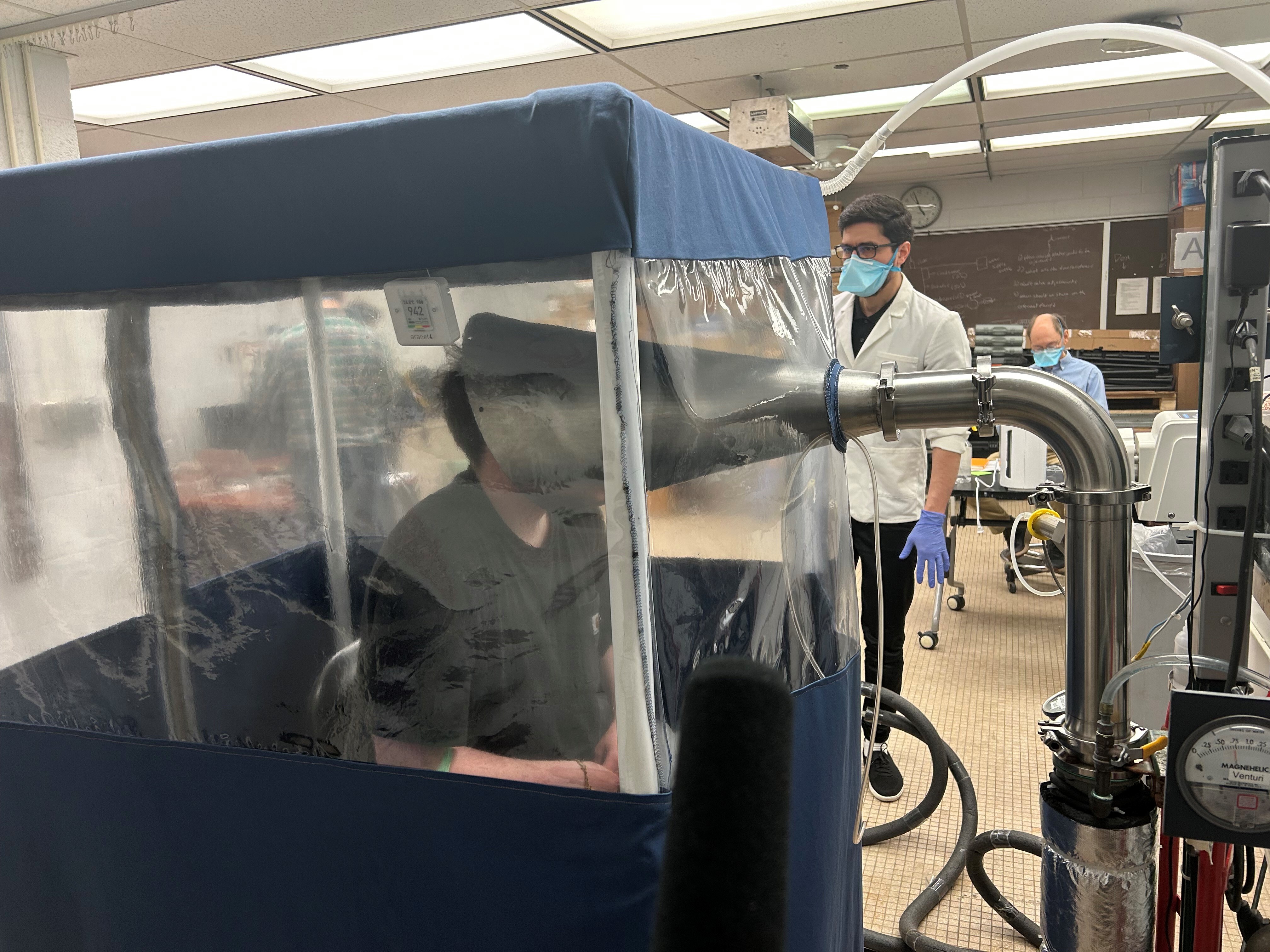 A person breathes inside the Gesundheit II, a machine that allows scientists to study the behavior of pathogens when they