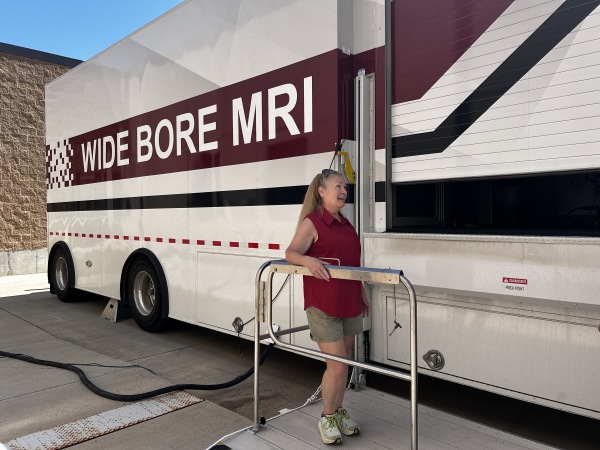 Patient Retta Jacobi stands on a metal platform that lifted her to the entrance of a mobile MRI unit at Southwest Healthcare Services in Bowman, North Dakota.