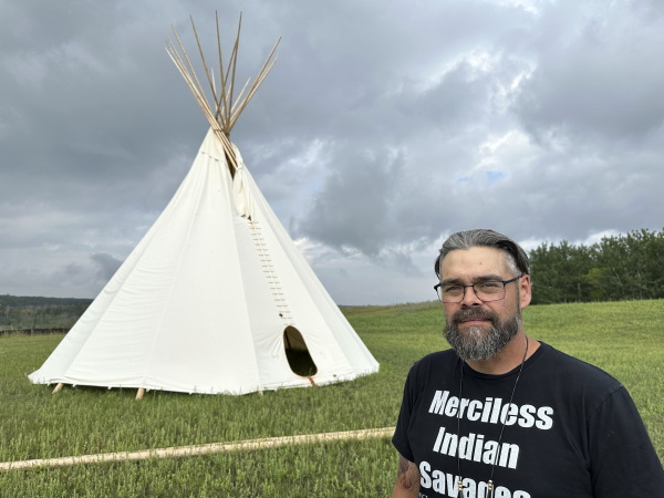 Jamie Azure, chair of the Turtle Mountain Band of Chippewa Indians, stands near a tepee outside the Turtle Mountain Recovery Center on the tribal nation’s reservation in Belcourt, N.D., in July.