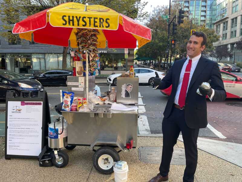Isaac Stein se tient devant son stand de hot-dogs « Shysters Dogs ».
