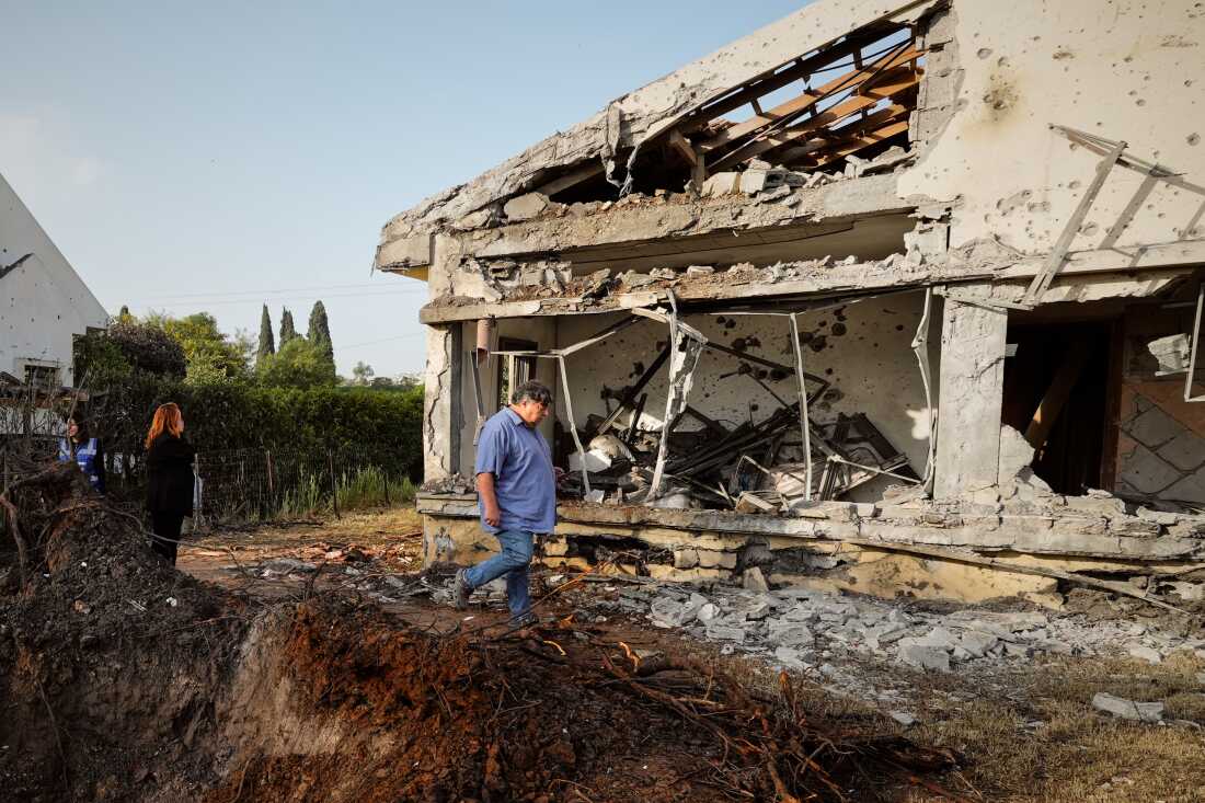 People inspect homes damaged by a projectile launched from Lebanon, in Haniel central Israel, on Thursday.