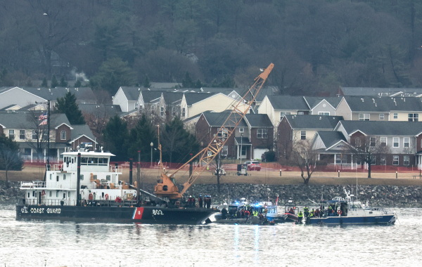 Search efforts are seen around a wreckage site of a deadly midair collision between an American Airlines jet and an Army helicopter, in the Potomac River near Ronald Reagan Washington National Airport on Friday in Arlington, Va.