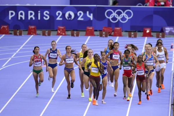 Runners compete during a heat in the women's 5000-meter run at the 2024 Summer Olympics, Friday, in Saint-Denis, France.