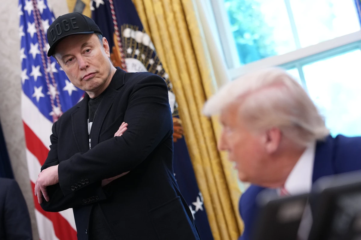 Elon Musk listens as President Trump speaks to reporters in the Oval Office on May 30. A week after the two traded social media disses and threats, Musk said Wednesday some of his posts 'went too far.'