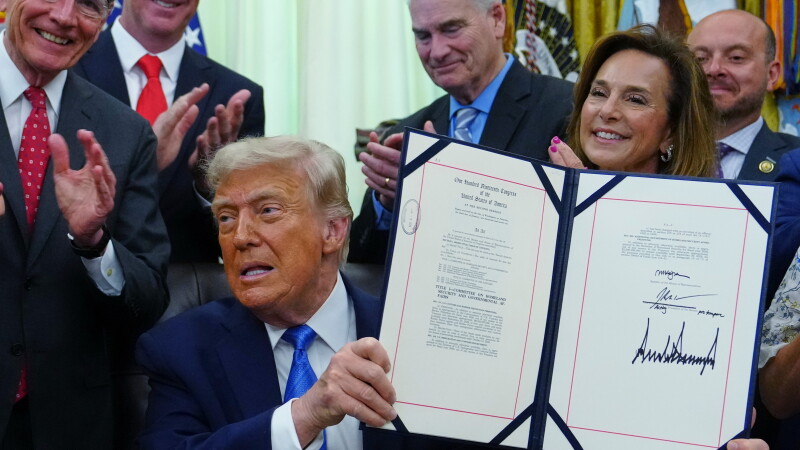 President Trump holds up a bill funding immigration enforcement after signing it in the Oval Office of the White House, Wednesday, June 10, 2026, in Washington. 