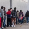 Asylum seekers queue at the entrance of Mexico's Refugee Help Commission and UNHCR offices in Tijuana, Mexico on January 24, 2025. (Photo by Guillermo Arias / AFP) (Photo by GUILLERMO ARIAS/AFP via Getty Images)
