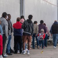 Asylum seekers queue at the entrance of Mexico's Refugee Help Commission and UNHCR offices in Tijuana, Mexico on January 24, 2025. (Photo by Guillermo Arias / AFP) (Photo by GUILLERMO ARIAS/AFP via Getty Images)