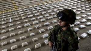 A Colombian Army soldier stands next to packages of seized cocaine during a press conference at a Military Base in Bahia Solano, department of Choco, Colombia, on March 14, 2015.