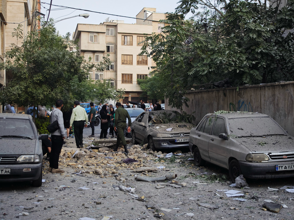 People look over damage to buildings following Israeli airstrikes on June 13, 2025 in Tehran, Iran.