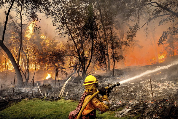 Firefighter Christian Moorhouse battles the Park Fire tears through the Cohasset community in Butte County, Calif., on Thursday, July 25, 2024. His crew was able to keep flames from reaching the mobile home they were protecting.