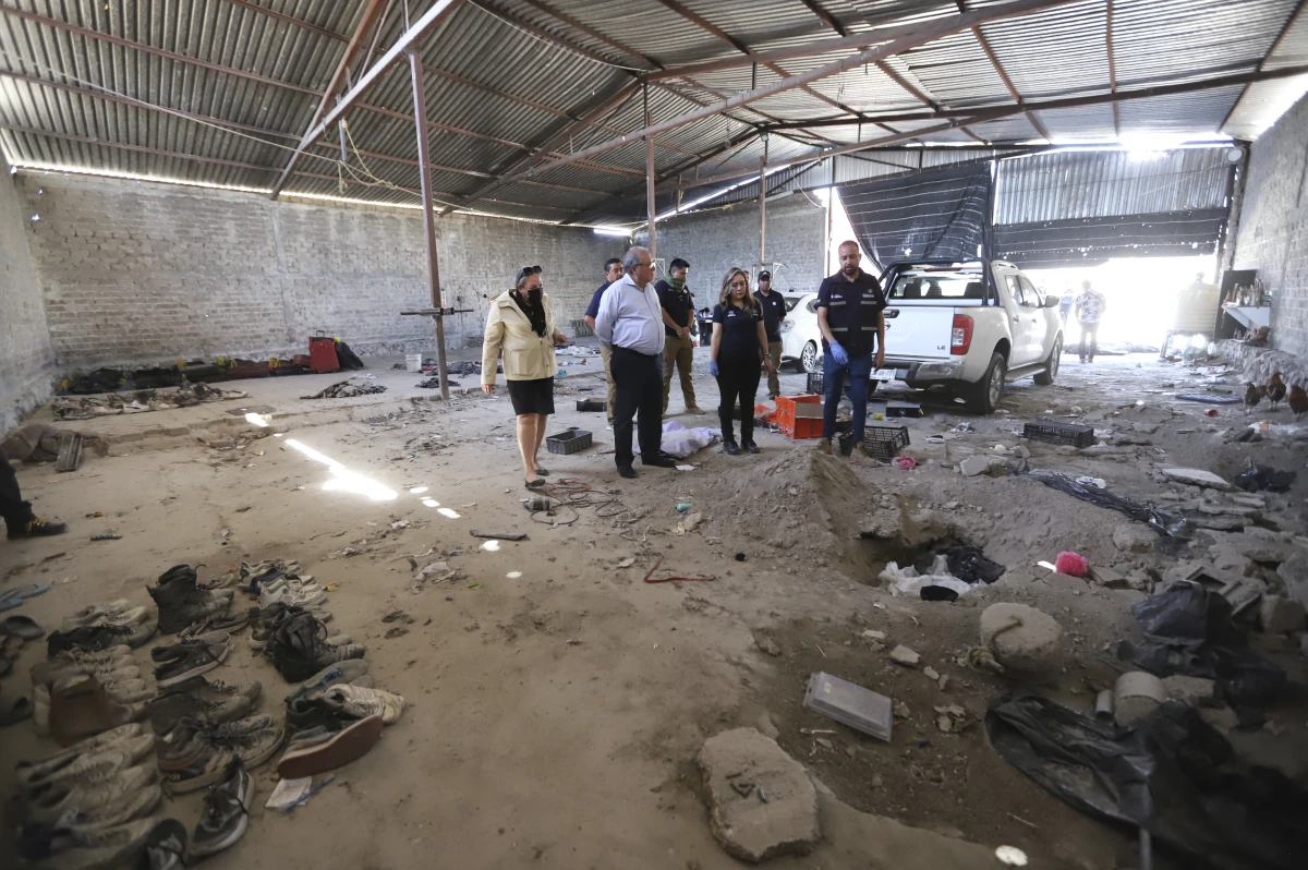 This photo released by the Jalisco State Attorney General's Office shows investigators inspecting the Izaguirre Ranch where skeletal remains were discovered in the municipality of Teuchitlan, Mexico on Tuesday.