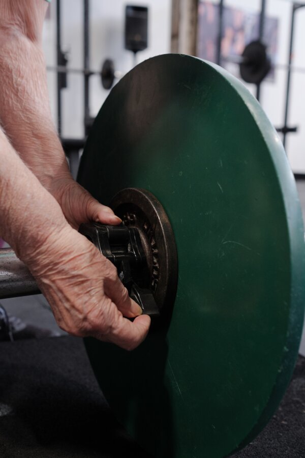 A young couple smiles‍ outside​ their brightly painted tiny home,surrounded by lush greenery.