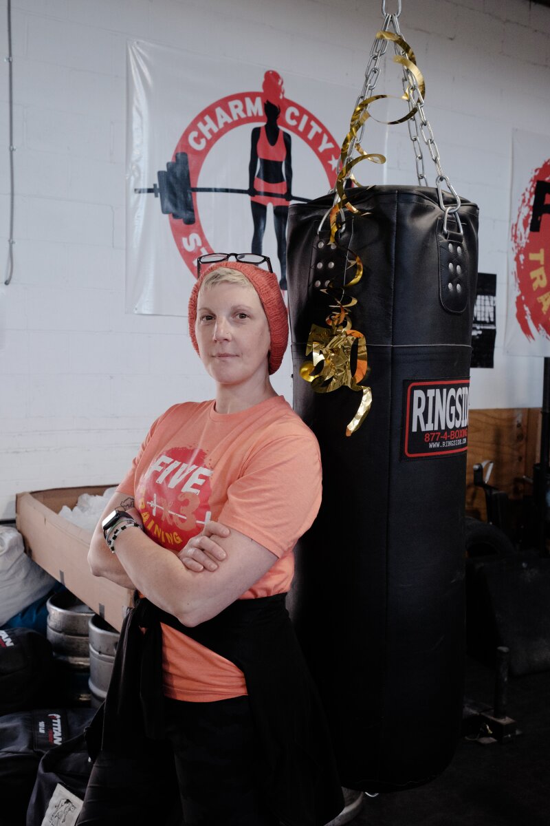 A⁤ young couple smiles outside their tiny home, surrounded by greenery.